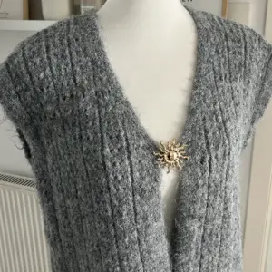 Strickweste Grau mit Brosche